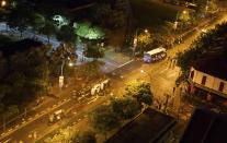 A view from a high-rise flat shows two overturned police cars (C) and several other damaged vehicles along Race Course Road following a riot near Singapore's Little India district December 9, 2013. Local media said a mob of about 400 set fire to an ambulance and police cars during the riot on Sunday, which started after a bus knocked down a pedestrian. REUTERS/Stringer (SINGAPORE - Tags: CIVIL UNREST)