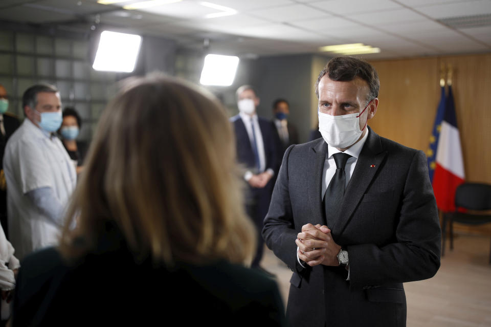 French President Emmanuel Macron, wearing a protective face mask, talks during a meeting with medical staff members during a visit in a child psychiatry department at Reims hospital, eastern France, to discuss the psychological impact of the COVID-19 crisis and the lockdown on children and teenagers in France, Wednesday, April 14, 2021. (Christian Hartmann/Pool via AP)