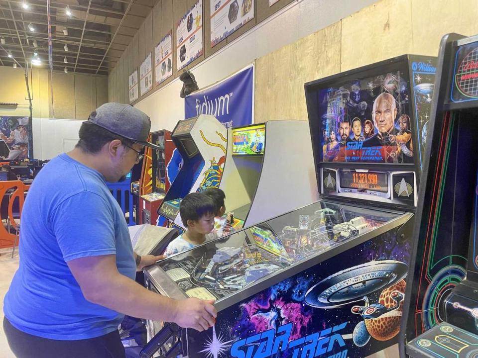 Jeff Garzona plays pinball on Monday while his son, Liam Garzona, watches. Garzona said that he used to play pinball at the laundromat near his house. Sonora Slater