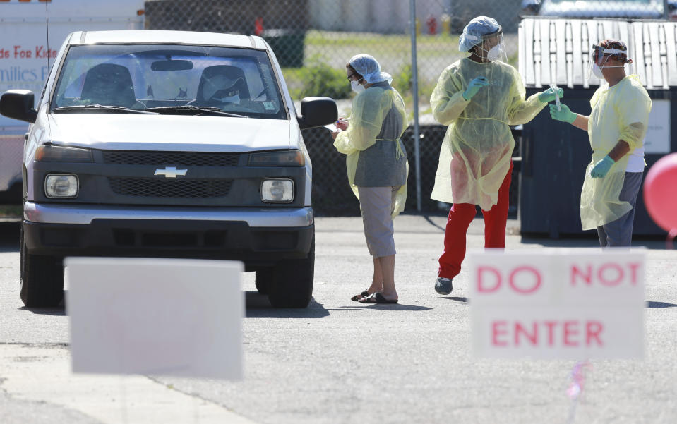 In this Thursday, June 11, 2020 photo, technicians begin gathering samples from area residents as part of a free COVID-19 testing center at the Family Resource Center on South Church Street in Tupelo, Miss. (Thomas Wells/The Northeast Mississippi Daily Journal via AP)