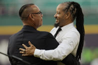 Former Cleveland baseball player Manny Ramirez, right, is embraced by former teammate Carlos Baerga, left, during induction ceremonies into the Cleveland Guardians Hall of Fame before a game between the Detroit Tigers and the Guardians, Saturday, Aug. 19, 2023, in Cleveland. (AP Photo/Sue Ogrocki)
