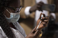 A health worker prepares a dose of the China's Sinopharm vaccine during the start of the vaccination campaign against the COVID-19 at the Health Ministry in Dakar, Senegal, Tuesday, Feb. 23, 2021. The country is also expecting nearly 1.3 million vaccine doses through the COVAX initiative. (AP Photo/Leo Correa)