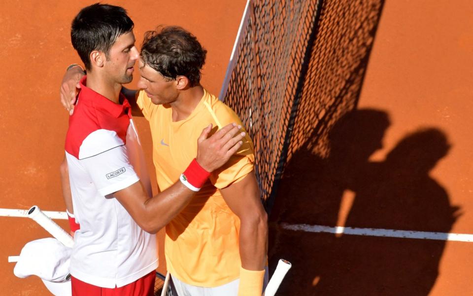 Rafael Nadal (R) and Novak Djokovic embrace at the net after a high-quality semi-final - AFP