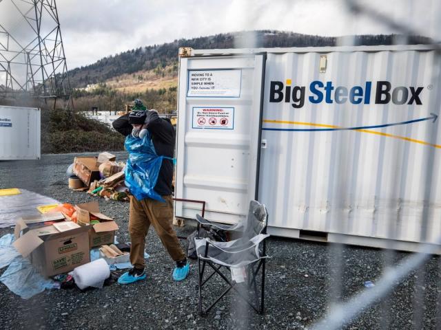 Two people clear out their BigSteelBox storage container on Thursday, Dec. 23, 2021, after it was damaged by floodwaters in Abbotsford, British Columbia. (Ben Nelms/CBC - image credit)
