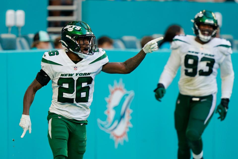 New York Jets cornerback Brandin Echols (26) gestures as he scored a touchdown after intercepting a pass by Miami Dolphins quarterback Tua Tagovailoa (1) during the second half of an NFL football game, Sunday, Dec. 19, 2021, in Miami Gardens, Fla. (AP Photo/Lynne Sladky)
