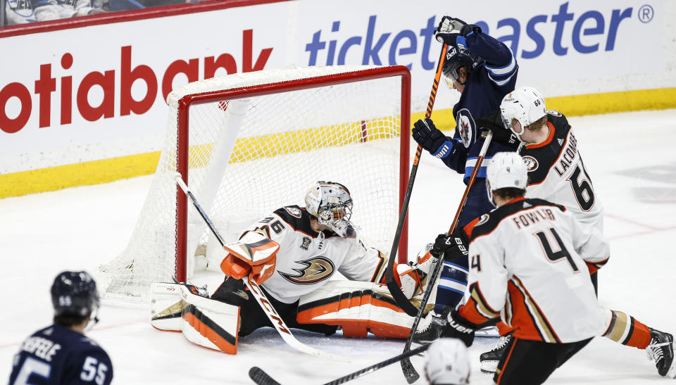 Winnipeg Jets' Tyler Toffoli, top right, scores his second goal against Anaheim Ducks goaltender John Gibson (36) during third-period NHL hockey game action in Winnipeg, Manitoba, Friday, March 15, 2024. (John Woods/The Canadian Press via AP)