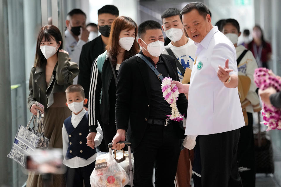 Thailand's Public Health Minister Anutin Charnvirakul, right, gives garland to Chinese tourists on their arrival at Suvarnabhumi International Airport in Samut Prakarn province, Thailand, Jan. 9, 2023.<span class="copyright">Sakchai Lalit—AP</span>