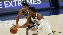 Utah Jazz guard Donovan Mitchell, front, pursues the ball with Denver Nuggets guard Gary Harris in the first half of an NBA basketball game Sunday, Jan. 17, 2021, in Denver. (AP Photo/David Zalubowski)