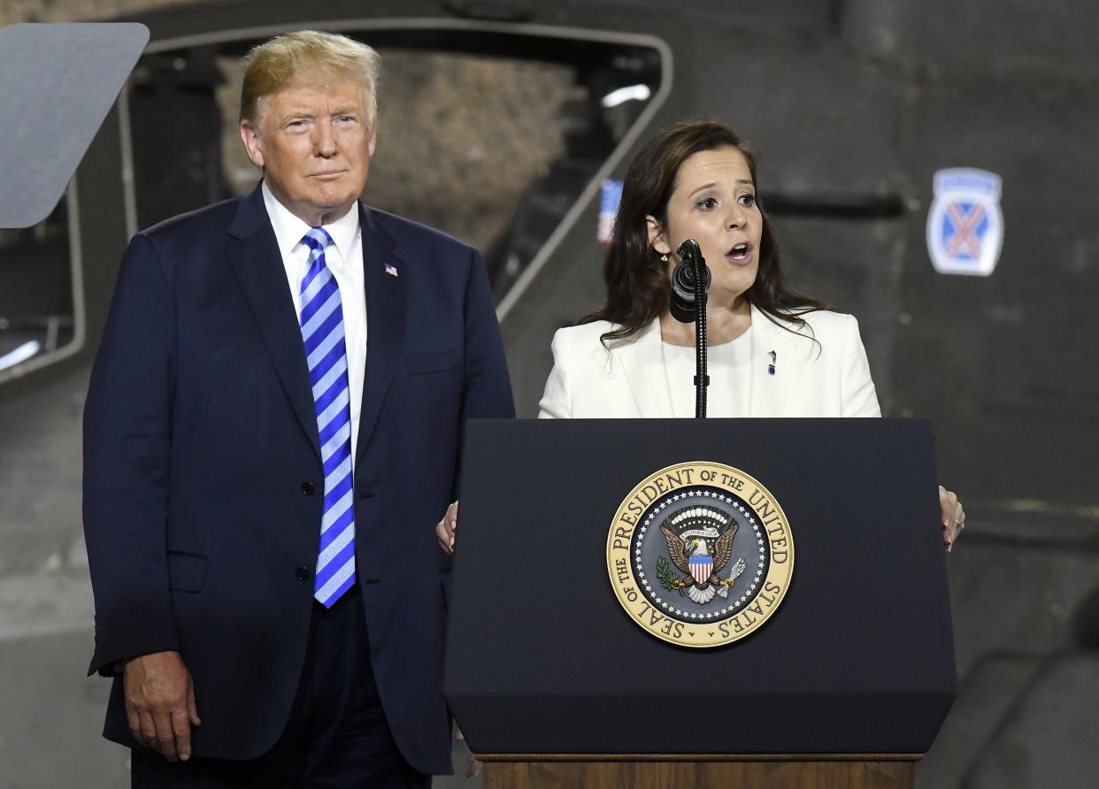 Then-President Trump listens as Rep. Elise Stefanik, R-N.Y., speaks in Fort Drum, N.Y., in 2018.