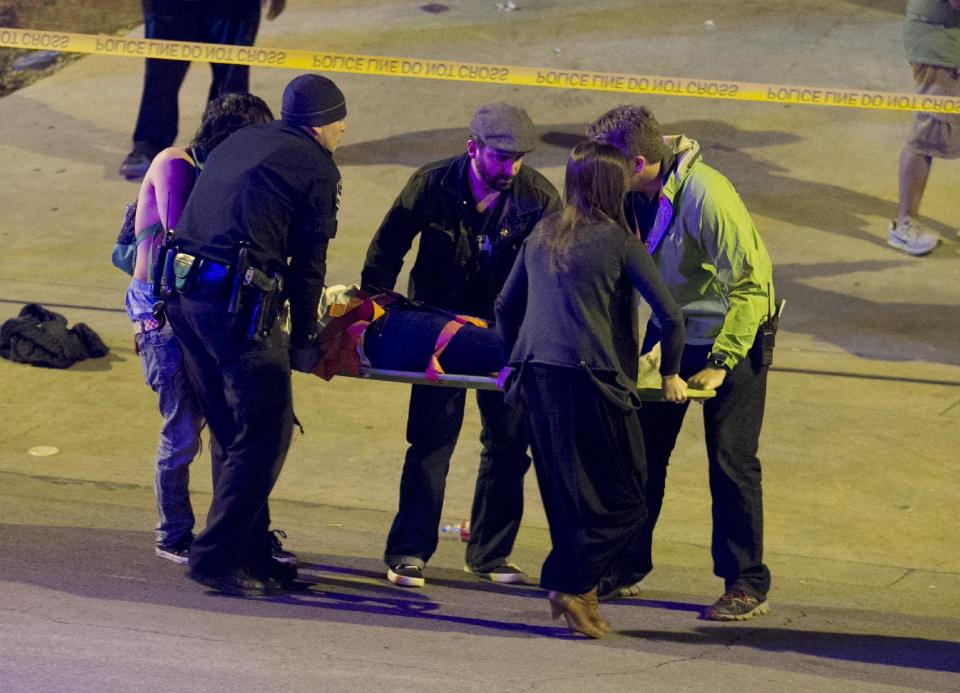 Bystanders and a police officers move a person who was struck by a car on Red River Street in downtown Austin, Texas, at SXSW on Wednesday March 12, 2014. Police say a man and woman have been killed after a suspected drunken driver fleeing from arrest crashed through barricades set up for the South By Southwest festival and struck the pair and others on a crowded street. (AP Photo/Austin American-Statesman, Jay Janner)