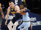 Memphis Grizzlies guard Ja Morant, right, steals the ball from Denver Nuggets center Nikola Jokic in the first half of an NBA basketball game Monday, April 19, 2021, in Denver. (AP Photo/David Zalubowski)