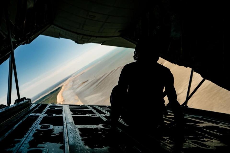 Madison Marsh sits on the ramp of a C-130J in flight