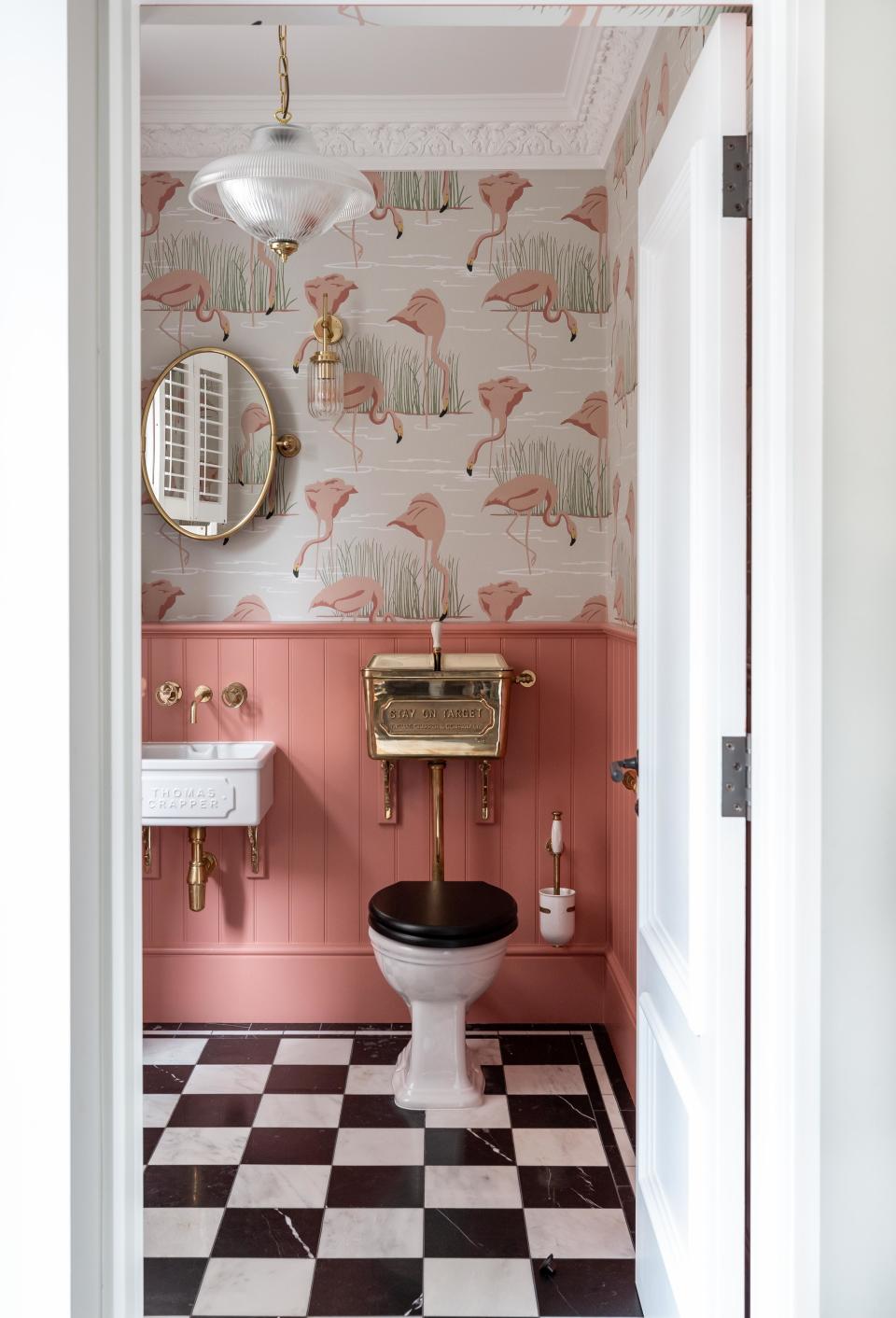 Bathroom with pink panelled wall and a toilet with a cast iron cistern