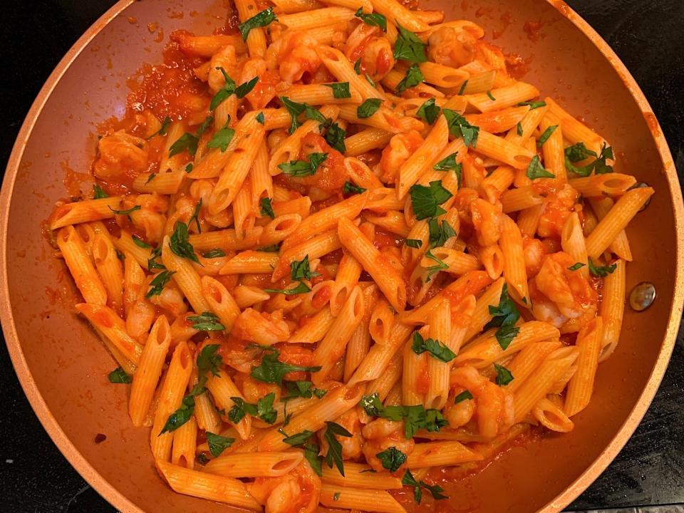 The shrimp, pasta, and sauce all mixed together, with parsley on top