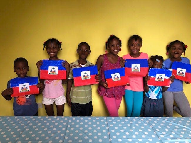 A group of children at Haiti's All Things New orphanage, which was founded by a Jacksonville couple, display small versions of their country's flag as civil unrest rages in the capital 20 miles away.