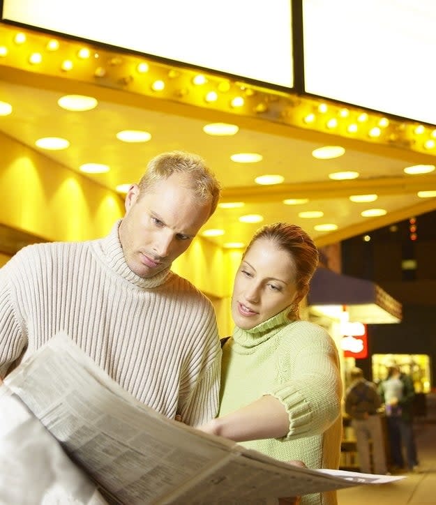 People looking at a newspaper together