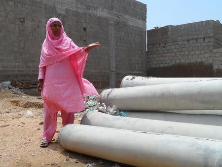 Sultana Javed shows sewer pipes bought recently on self-help basis for her street in Gulshan-e-Zia colony in Orangi Town, Karachi, Pakistan August 26, 2016. Picture taken August 26, 2016. Thomson Reuters Foundation/Aamir Saeed