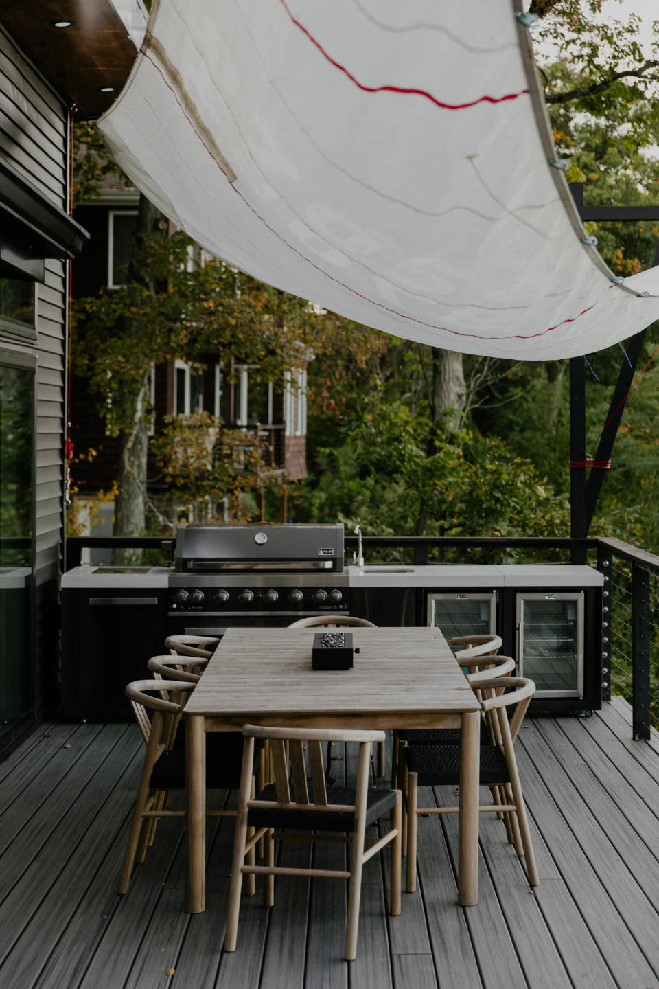 Fabric from an actual vintage sail creates shade for the outdoor dining area.