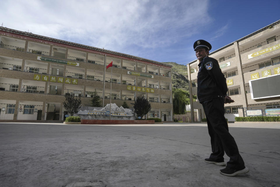 A security guard stands watch at the Shangri-La Key Boarding School during a media-organized tour in Dabpa county, Kardze Prefecture, Sichuan province, China on Sept. 5, 2023. Village schools have been shuttered across China's Tibet and replaced with centralized boarding schools that critics say represents forced assimilation. Activists estimate 1 million Tibetan children study at such boarding school. (AP Photo/Andy Wong)