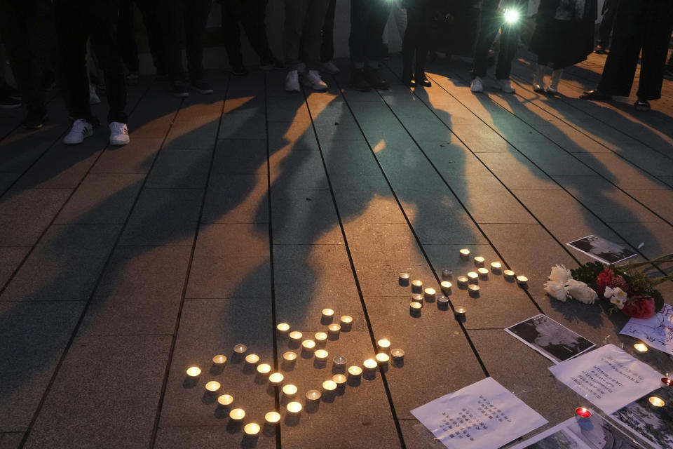 University students form Chinese words "Democracy" with candlelights at the site after the "Goddess of Democracy" statue, a memorial for those killed in the 1989 Tiananmen crackdown, was removed from the Chinese University of Hong Kong, Friday, Dec. 24, 2021. The university early Friday morning took down the statue that was based on a figure created by art students and brought to the square shortly before the crackdown in which hundreds of people were killed. (AP Photo/Vincent Yu)