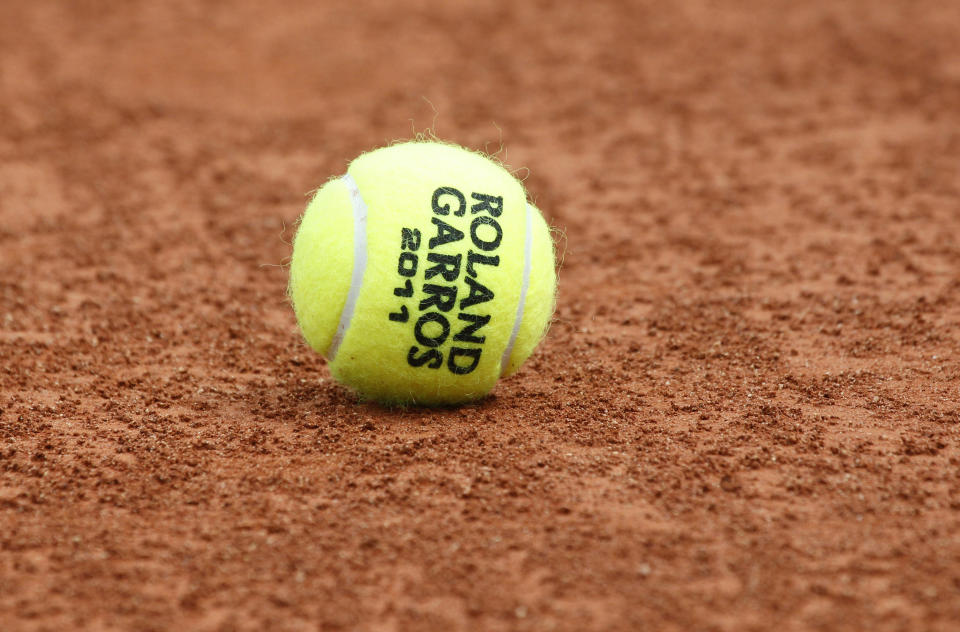 FILE - In this May 20, 2011, file photo, a tennis ball is seen on the clay at the Roland Garros stadium in Paris. The French Open begins Sunday, Sept. 27, 2020. (AP Photo/Christophe Ena, File)