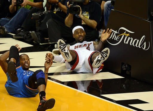 LeBron James (R) of the Miami Heat and Kevin Durant (L) of the Oklahoma City Thunder take a fall during Game 3 of the NBA Finals on June 17, 2012 at the American Airlines Arena in Miami, Florida. The Heat won 91-85 to take a 2-1 lead in the best-of-seven series