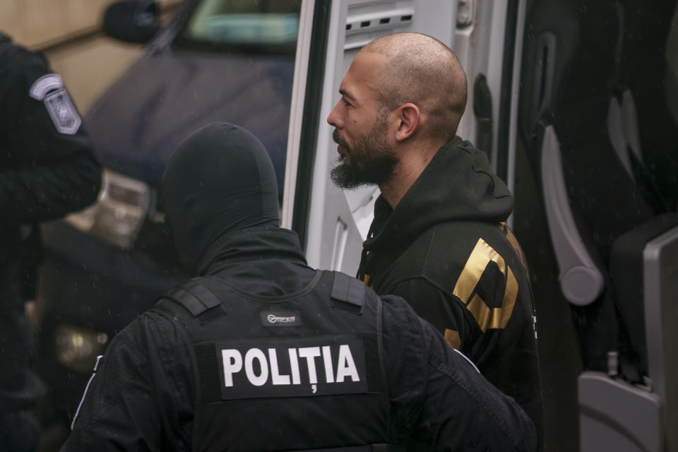 Police officers escort Andrew Tate, center, to the Court of Appeal in Bucharest, Romania, Tuesday, March 12, 2024. Online influencer Andrew Tate was detained in Romania and handed an arrest warrant issued by British authorities, his spokesperson said Tuesday. (AP Photo/Andreea Alexandru)