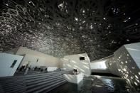 FILE PHOTO: Visitors look at the dome hall design of the Louvre Abu Dhabi Museum in Abu Dhabi