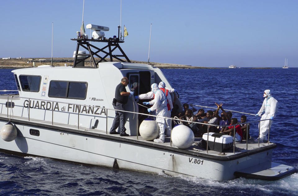 Migrants are evacuated by Italian Coast guards from the Open Arms Spanish humanitarian boat at the coasts of the Sicilian island of Lampedusa, southern Italy, Saturday, Aug.17, 2019. Italy’s hard-line interior minister buckled under pressure Saturday and agreed to let 27 unaccompanied minors leave a migrant rescue ship after two weeks at sea, temporarily easing a political standoff that has threatened the viability of the populist government. (AP Photo/Francisco Gentico)