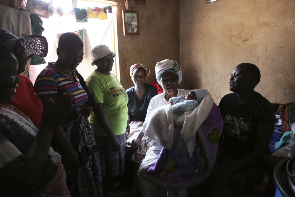 72-year old grandmother Esther Zinyoro Gwena holds one of the babies she helped deliver in her tiny apartment in the poor surburb of Mbare in Harare, Zimbabwe, in this Saturday, Nov. 16, 2019. Grandmother Esther Zinyoro Gwena claims to be guided by the holy spirit and has become a local hero, as the country’s economic crisis forces closure of medical facilities, and mothers-to-be seek out untrained birth attendants.(AP Photo/Tsvangirayi Mukwazhi)