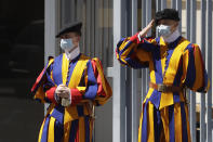 Swiss Guard stand at the entrance of the Vatican Monday, May 4, 2020. The Vatican is postponing the annual swearing-in ceremony for its new crop of Swiss Guards, a commemoration usually held each May 6 to honor the guardsmen who died while protecting the pope during the 1527 Sack of Rome. The Swiss Guards said Monday that due to the ongoing coronavirus emergency, the pomp-filled ceremony will now be held Oct. 4. (AP Photo/Alessandra Tarantino)