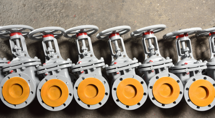 Several new gray valves, for water or gas, lie on the floor at the factory. The valves are gray for water or gas at the factory of the manufacturer