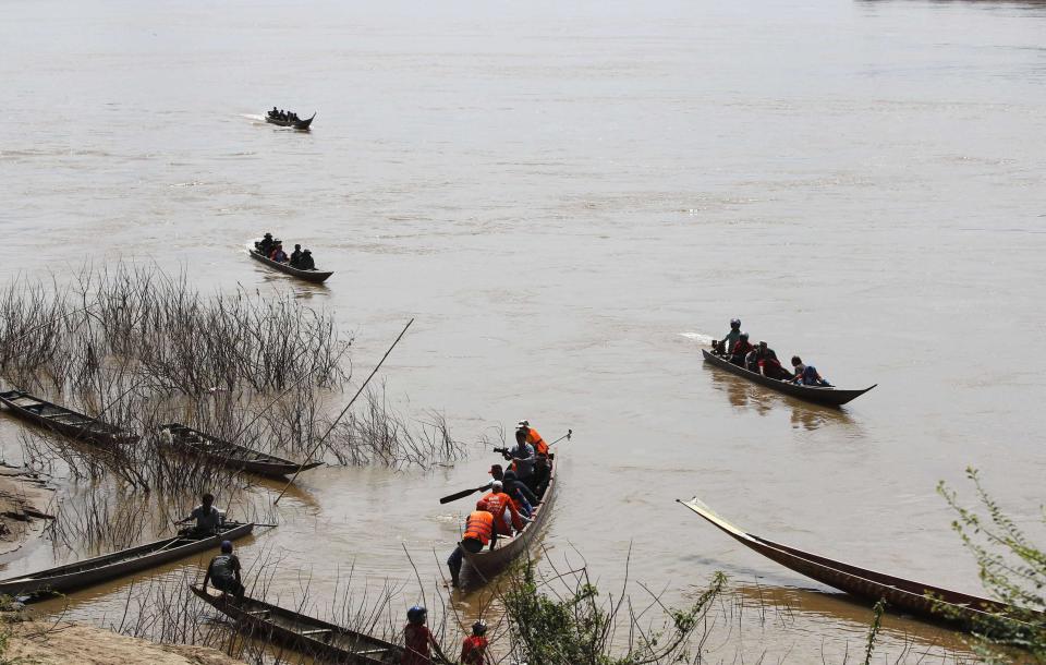 Rescue personnel on boats search crash site of an ATR-72 turboprop plane, in Laos, near Pakse