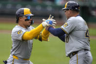 Milwaukee Brewers' William Contreras, left, rounds third to greetings from third base coach Jason Lane after hitting a solo home run off Pittsburgh Pirates starting pitcher Mitch Keller during the first inning of a baseball game in Pittsburgh, Thursday, April 25, 2024. (AP Photo/Gene J. Puskar)