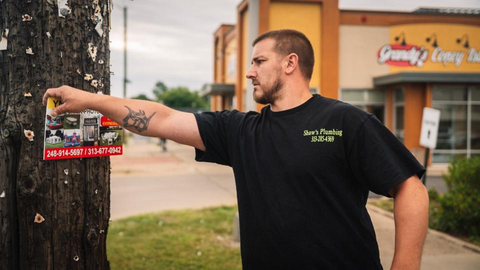 William Shaw taking down illegally posted signs on the corner of 7 mile and Evergreen Road.