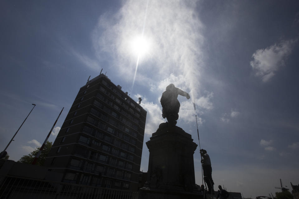 In this Friday June 12, 2020, file image, A municipal worker uses a high pressure water cleaner to remove the paint from the statue of Piet Hein in Rotterdam, Netherlands, Friday, June 12, 2020. Dutch activists have spray painted the words "killer" and "thief" and daubed red paint on a statue of a man regarded by many as a naval hero from the 17th-century Golden Era of Dutch trade and colonial expansion. Activists spurred by the Black Lives Matter protests in the United States are seeking to shed more light on the Dutch colonial past and tackle what they call ingrained racism and discrimination in this nation that was once known as a beacon of tolerance. (AP Photo/Peter Dejong, File)