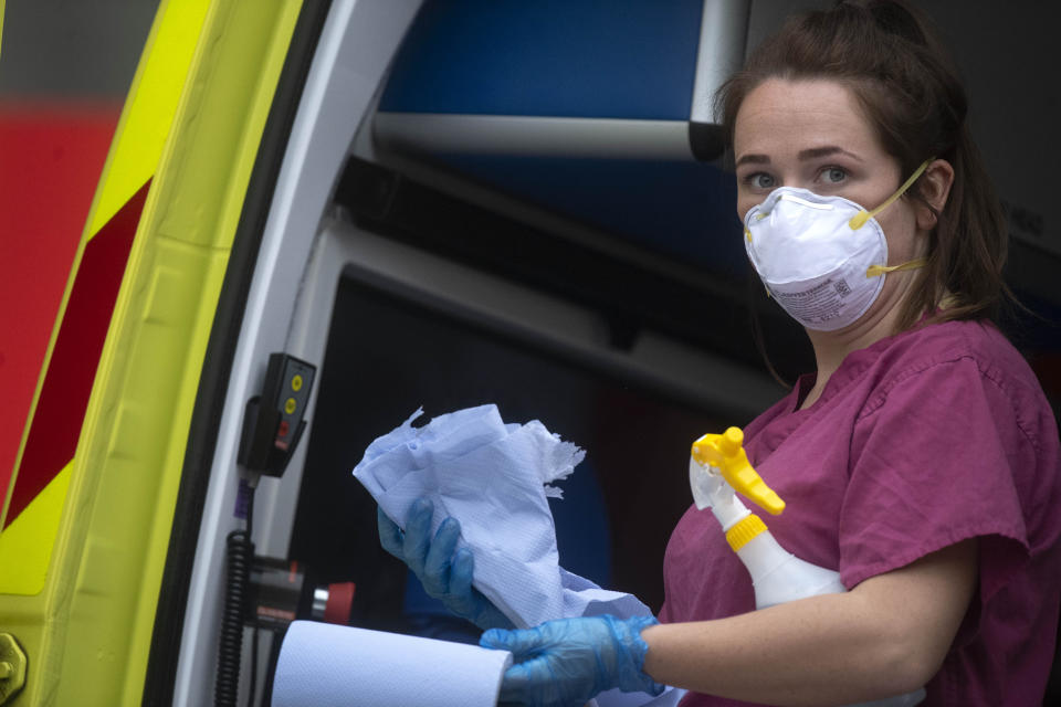 A London Ambulance worker wearing PPE cleans an ambulance after a patient is brought into St Thomas' Hospital in London as the UK continues in lockdown to help curb the spread of the coronavirus.