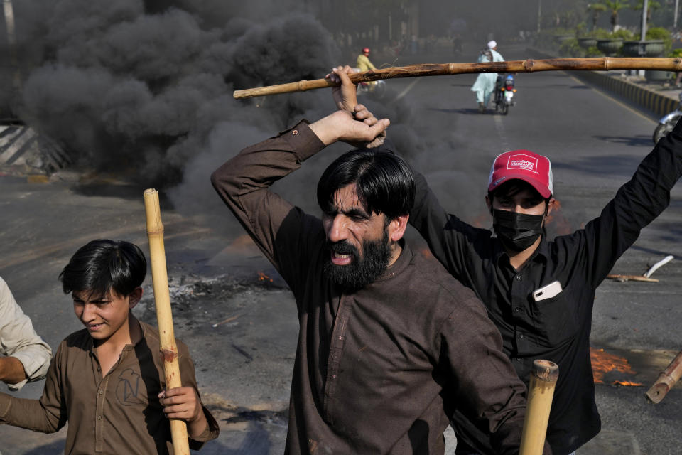 Supporters of Pakistan's former Prime Minister Imran Khan chant slogans after burning billboards during a protest against the arrest of their leader, in Lahore, Pakistan, Tuesday, May 9, 2023. Khan was arrested Tuesday as he appeared in a court in the country’s capital, Islamabad, to face charges in multiple graft cases. Security agents dragged Khan outside and shoved him into an armored car before whisking him away. (AP Photo/K.M.Chaudary)