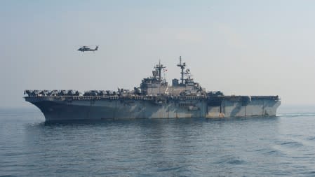 An SH-60 Sea Hawk flies over the U.S. Navy amphibious assault ship USS Boxer during a vertical replenishment-at-sea in the Arabian Gulf