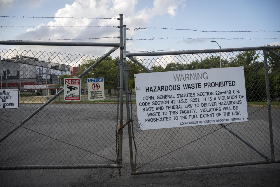 A former trash incinerator that closed earlier in the year is seen through locked gates in Hartford, Conn., Tuesday, Sept. 13, 2022. Air pollution from the incinerator was one of the leading causes of increased asthma rates among residents in the area. (AP Photo/Wong Maye-E)