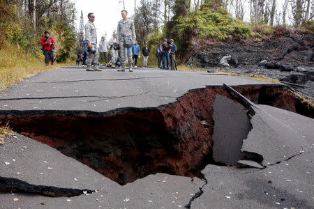 Journalists and soldiers of the Hawaii National Guard document road damage in Leilani Estates during ongoing eruptions of the Kilauea Volcano in Hawaii, U.S., May 18, 2018. REUTERS/Terray Sylvester