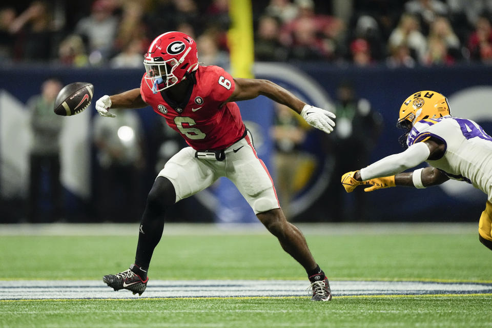 CORRECTS ID TO LSU LINEBACKER HAROLD PERKINS JR. (40), NOT LSU CORNERBACK JARRICK BERNARD-CONVERSE (24) - Georgia running back Kenny McIntosh (6) briefly loses his grip on the ball as he runs away from LSU linebacker Harold Perkins Jr. in the second half of the Southeastern Conference Championship football game Saturday, Dec. 3, 2022 in Atlanta. (AP Photo/John Bazemore)