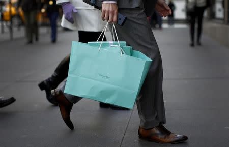 A shopper carries bags from Tiffany & Co. jewelers along 5th Avenue in New York City, April 4, 2013. REUTERS/Mike Segar