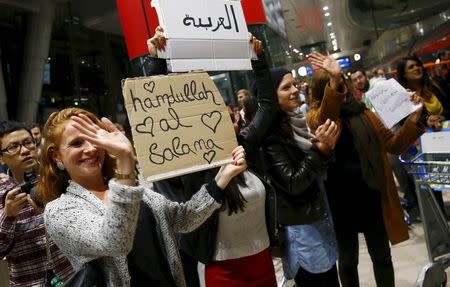 Wellwishers applaud and hold up signs welcoming migrants as Syrian families disembark a train that departed from Budapest's Keleti station at the railway station of the airport in Frankfurt, Germany, early morning September 6, 2015. REUTERS/Kai Pfaffenbach