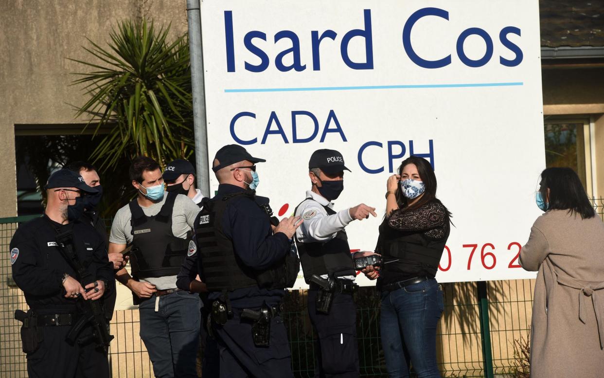 Police officers stand at the entrance of the Isard COS Reception Centre for Asylum Seekers (CADA) in Pau - GAIZKA IROZ /AFP