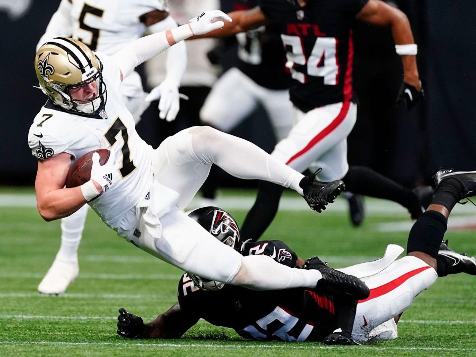 Taysom Hill is tackled by the Atlanta Falcons defense.