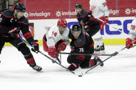 Carolina Hurricanes' Jordan Staal (11) and Brady Skjei (76) battle Detroit Red Wings' Robby Fabbri (14) for the puck during the first period of an NHL hockey game in Raleigh, N.C., Thursday, March 4, 2021. (AP Photo/Chris Seward)