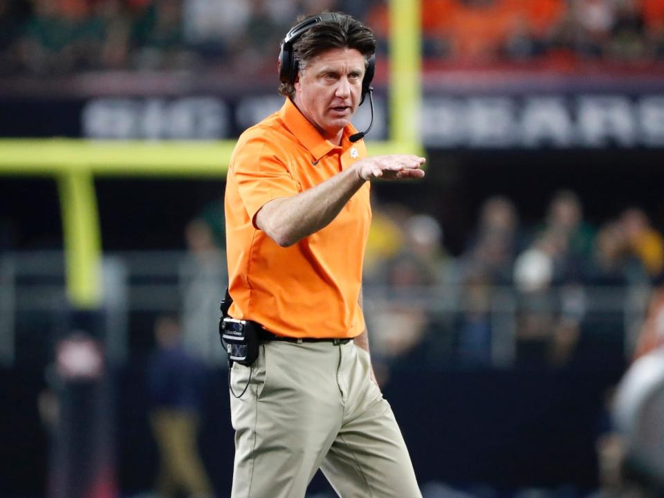 Mike Gundy walks onto the field during a game in 2021.