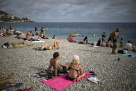 Tourists enjoy the beach in Nice, southern France, Friday, Aug 28, 2020. The Tour de France sets off shrouded in uncertainty in the face of the coronavirus pandemic and mounting infections in France. (AP Photo/Daniel Cole)