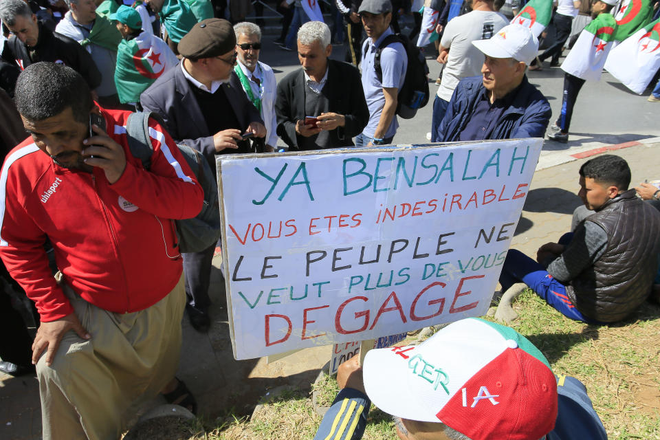 A placard reads "Bensalah you are unwanted. The people no longer want you. Get out" during a protest in Algiers, Friday, April 26, 2019. Algerians are massing for a 10th week of protests against their country's ruling class, calling for the ex-president's brother to be put on trial. (AP Photo/Anis Belghoul)